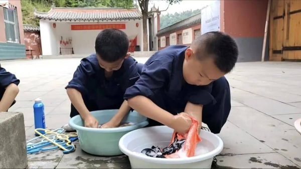 image shows young students washing clothes