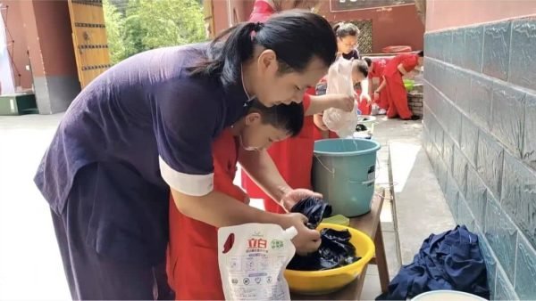 image shows young disciples learning how to wash clothes at the summer camp