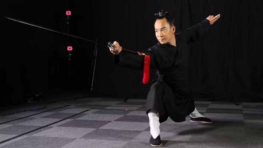 image shows master qingfengzi showing one of the weapon moves of wudang kung fu