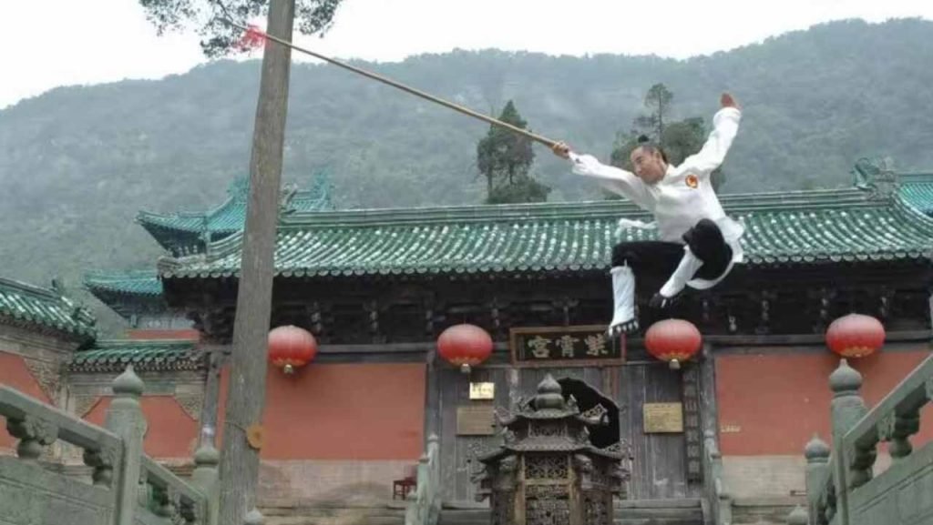 image shows master qingfengzi performing with a stick, wudang kung fu weapons